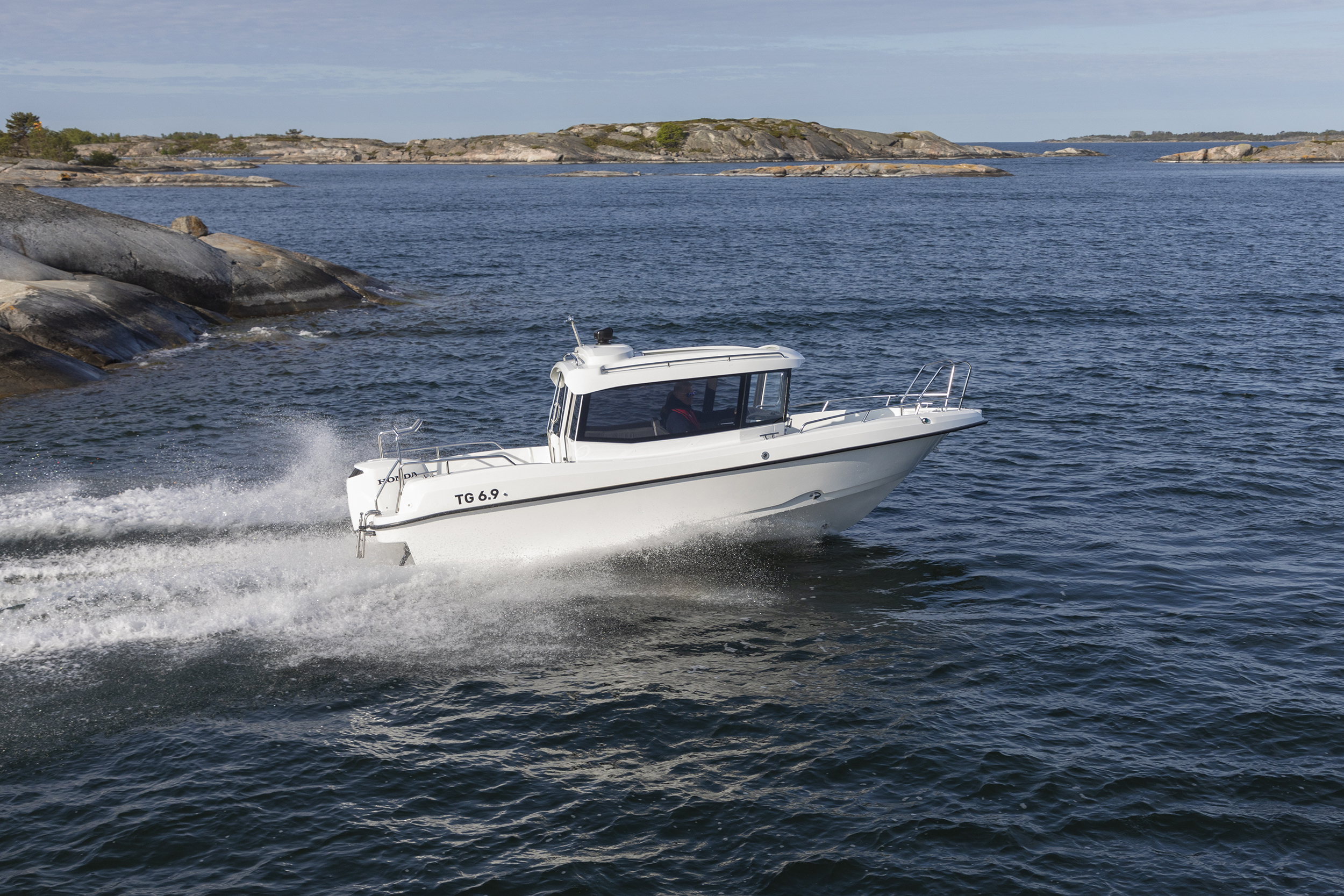 TG 6.9 kabinbåten med Honda-utombordare kör i hög fart i finska skärgården.