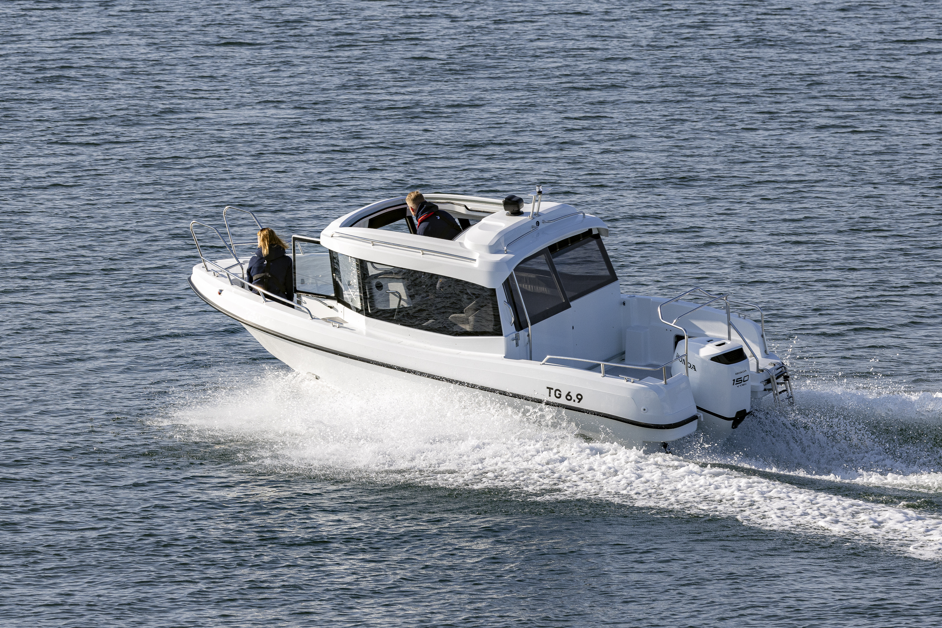 TG 6.9 -kabinbåt kör i hög hastighet genom öppet hav med takluckan öppen.