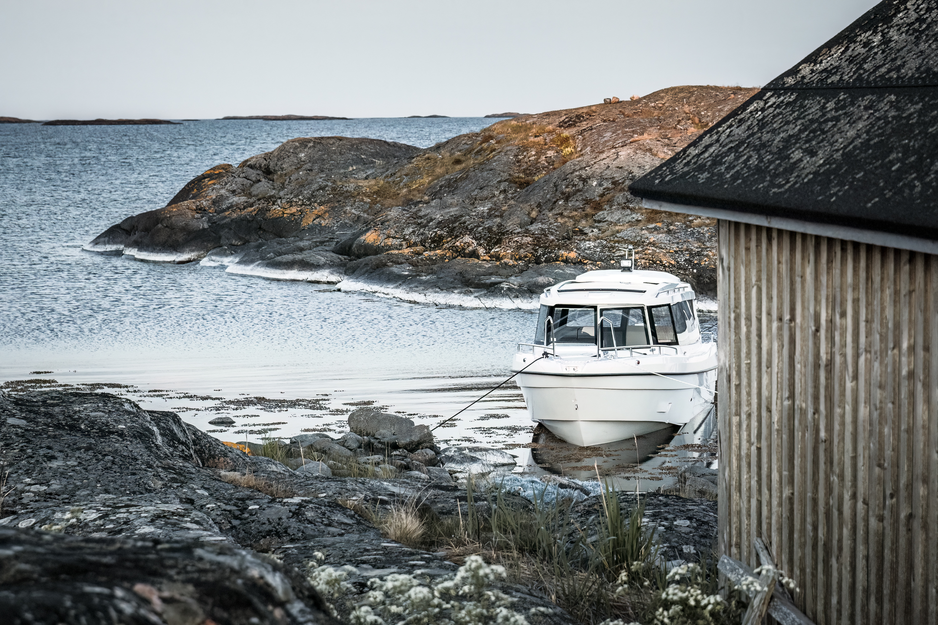 TG 7.9 cabin boat in the outer archipelago. In the foreground an old fishing hut, beautiful low sea cliffs and open sea in the background.